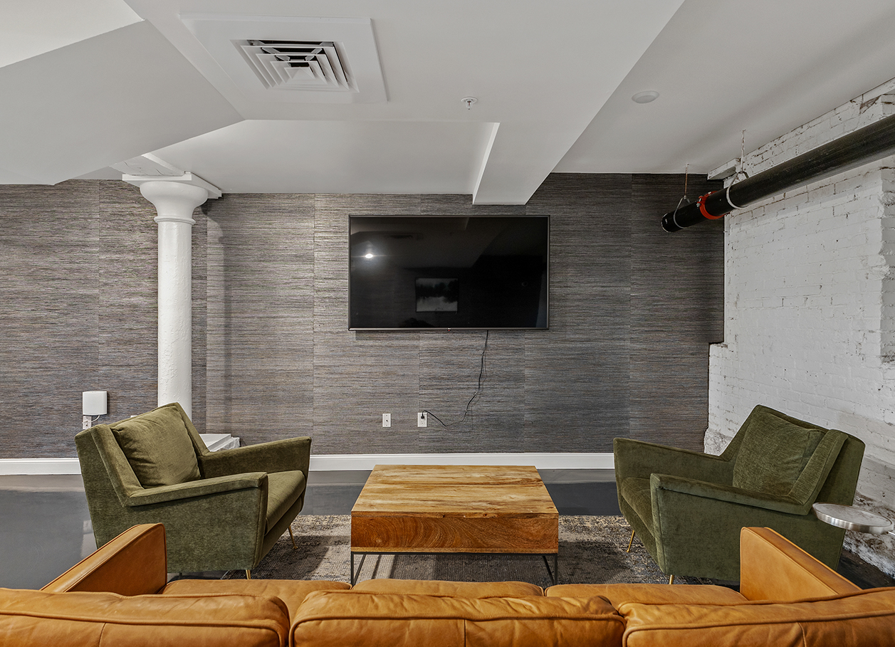 Photo of sofas and a television in the lounge area at 2 River Street.