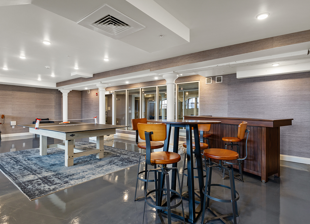 Photo of a seating area near the ping pong table in the recreation room at 2 River Street.