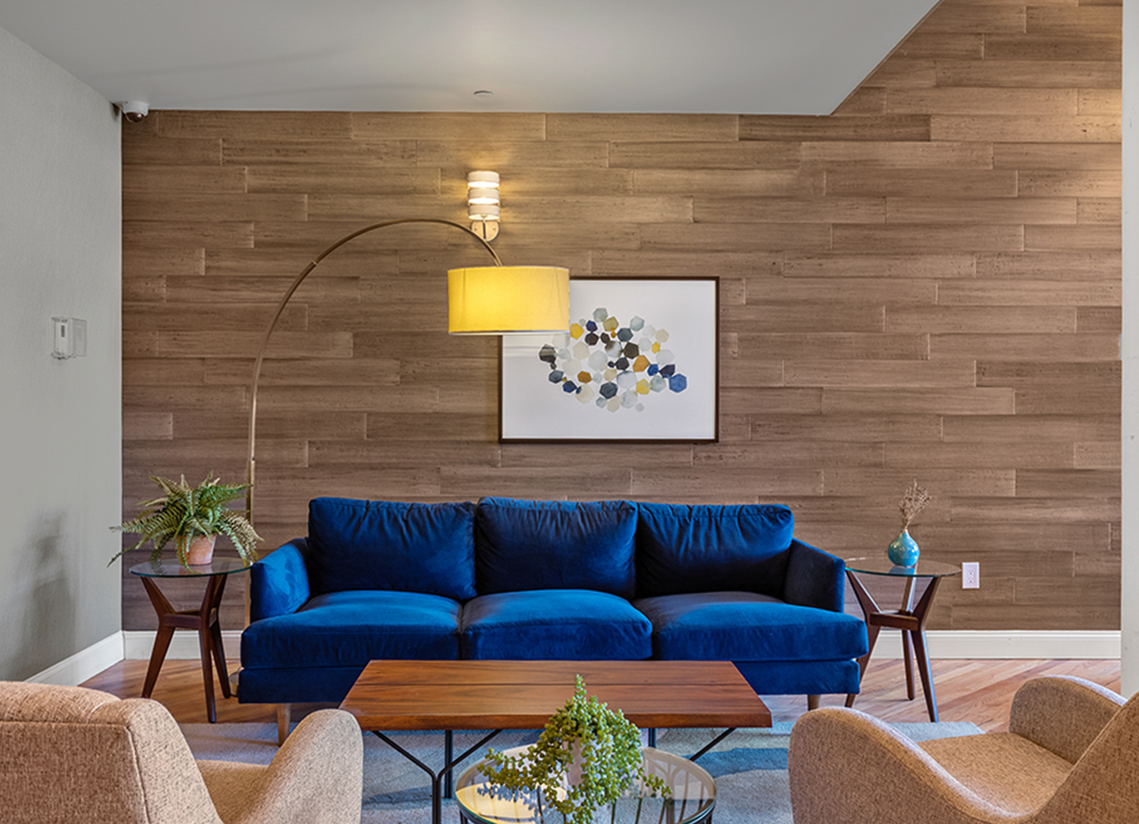 Photo of a couch and chairs in the lobby seating area of 2 River Street.