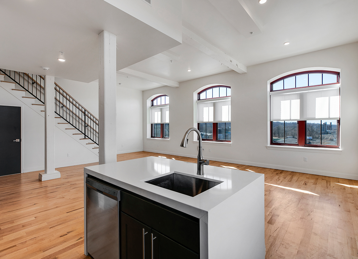 Photo looking at the living area from behind the kitchen sink area of an apartment at 2 River Street.