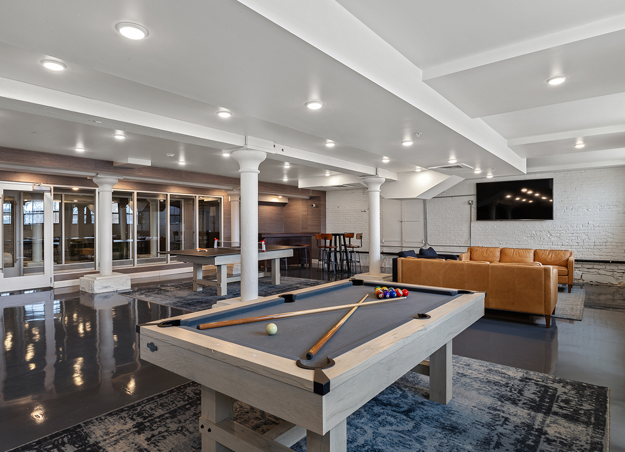 Photo of the full recreation room from behind the pool table area at 2 River Street